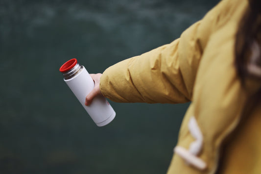 person holding white tumbler