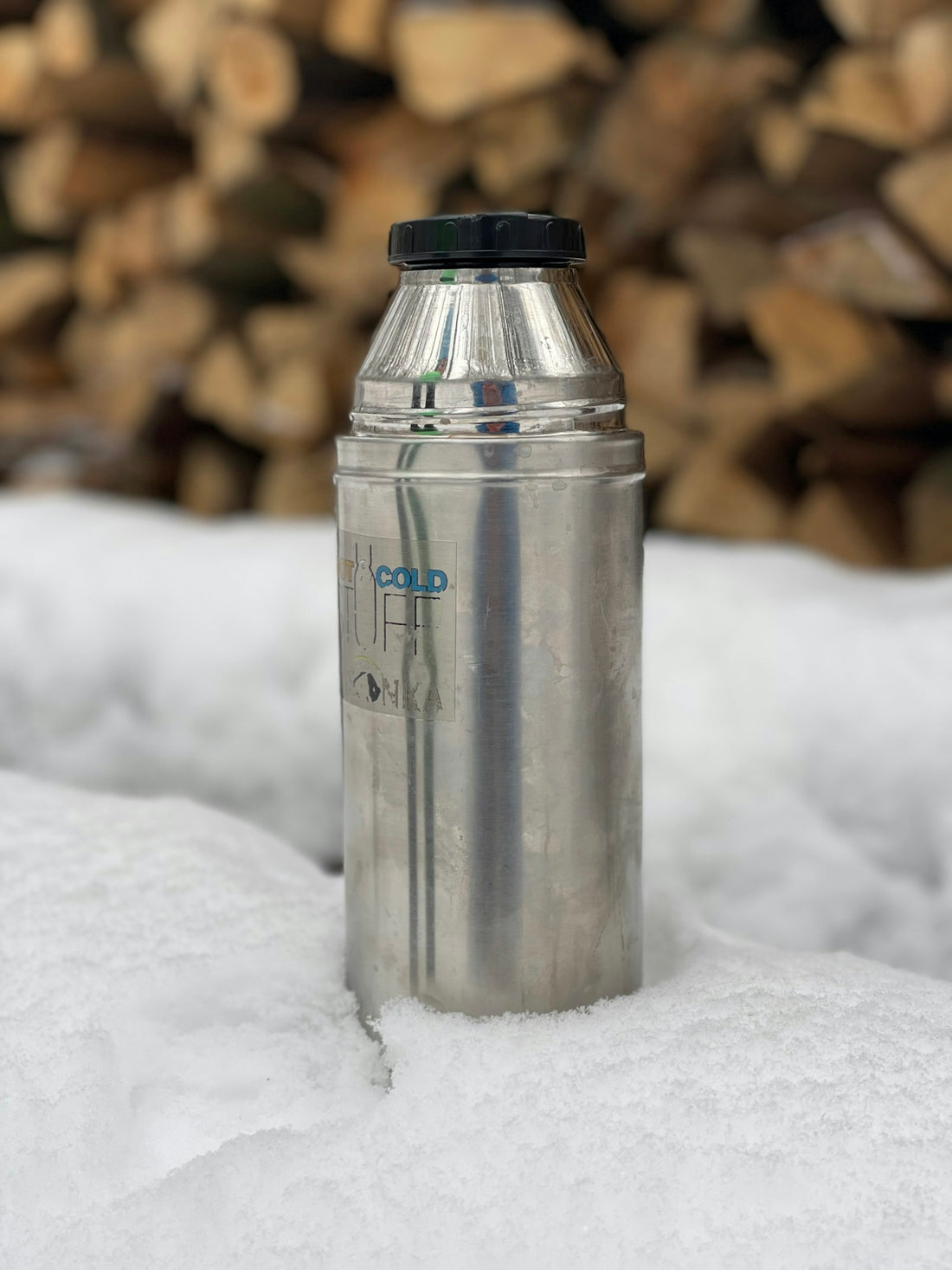 a stainless steel water bottle sitting on top of a pile of snow