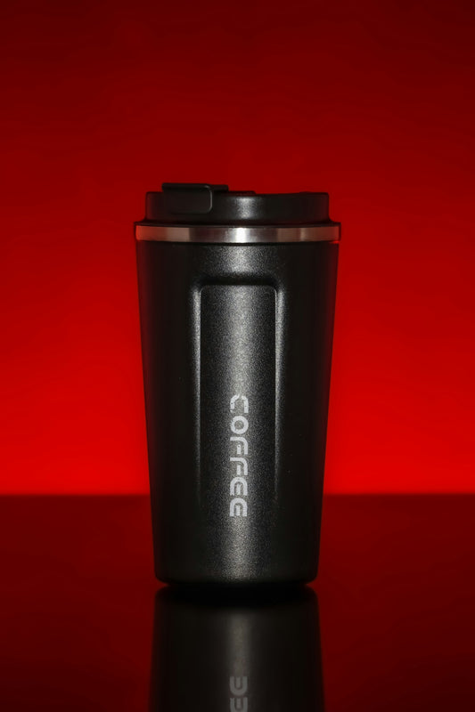 Black coffee tumbler against a red background
