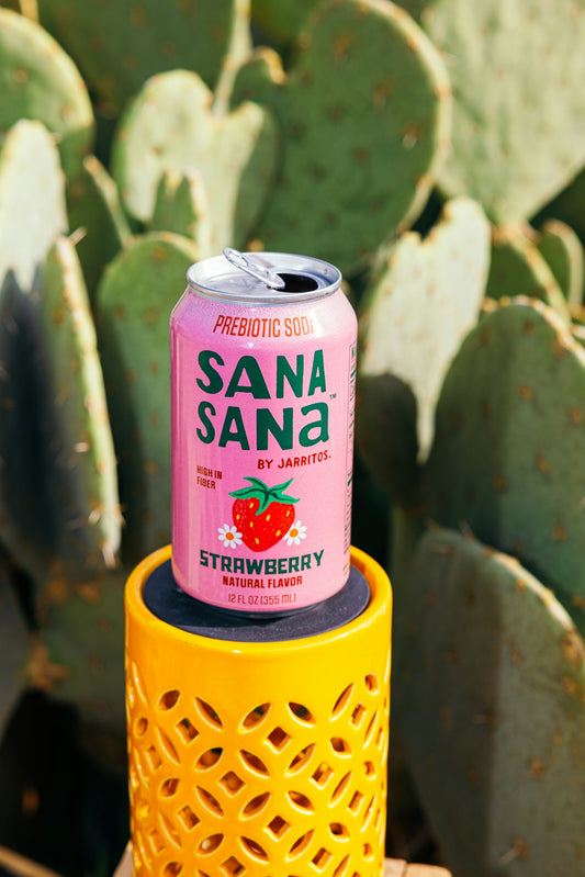 Strawberry sana sana soda can on yellow object, cactus background.